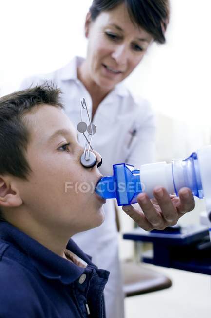 Preteen garçon subissant un test de fonction pulmonaire avec infirmière . — Photo de stock
