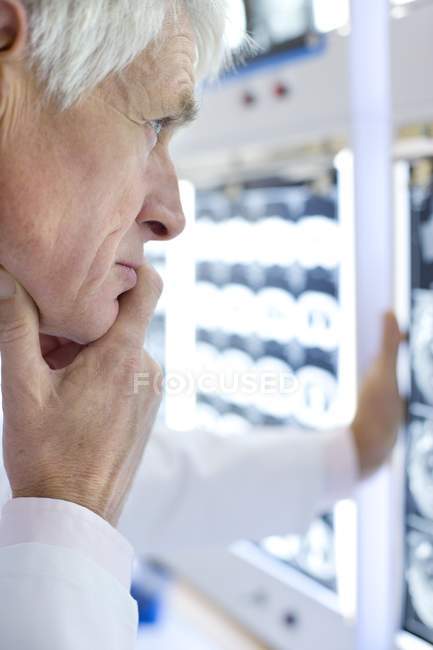 Старший рентгенолог изучает компьютерную томографию в больнице . — стоковое фото