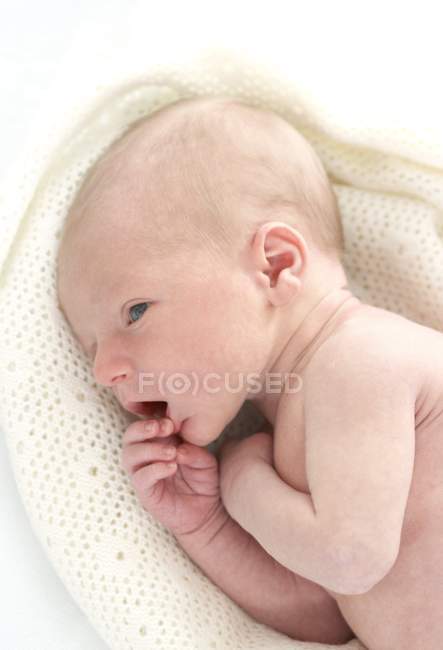 Newborn baby boy lying on white blanket. — Stock Photo