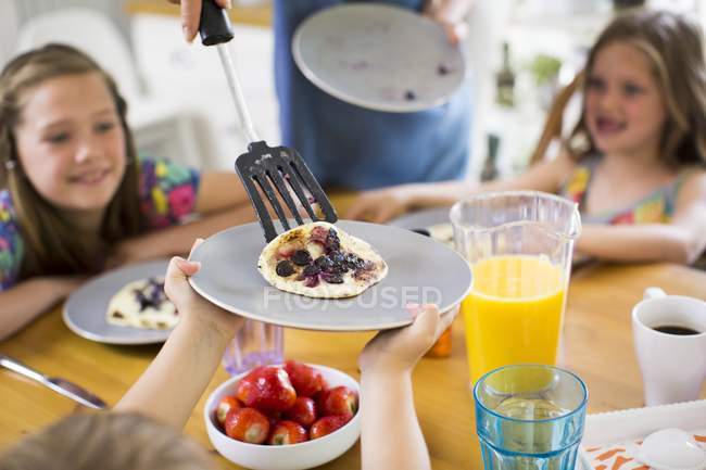 Boy holding plate with pancake being served. — Stock Photo