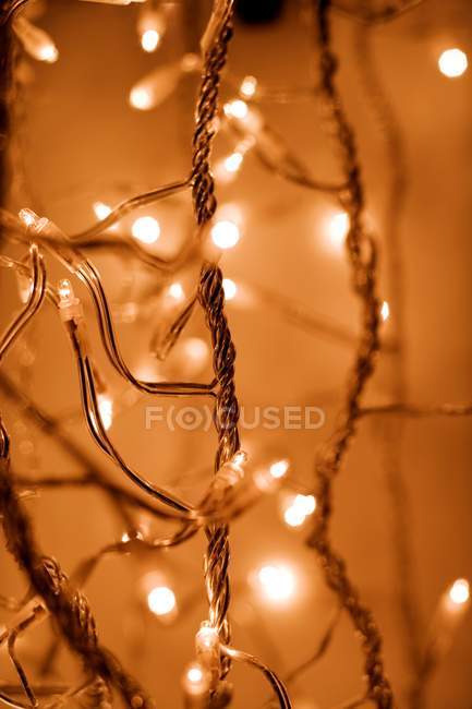 Close-up of hanging glowing Christmas lights. — Stock Photo