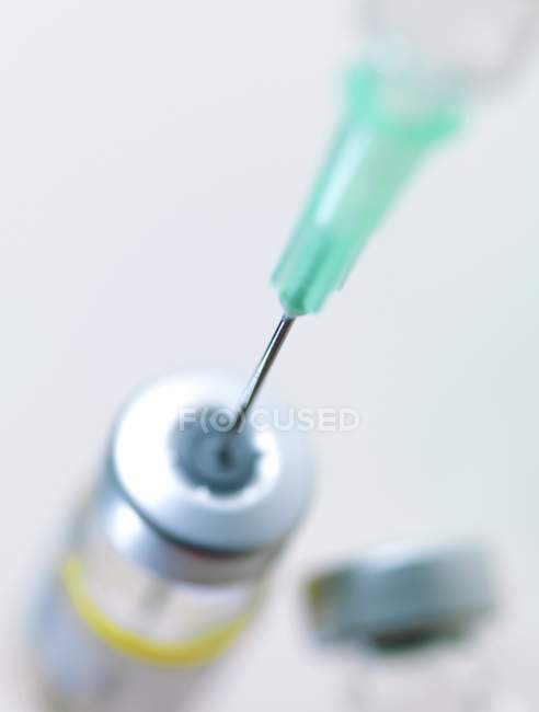 Aguja insertada en el vial de la vacuna . - foto de stock