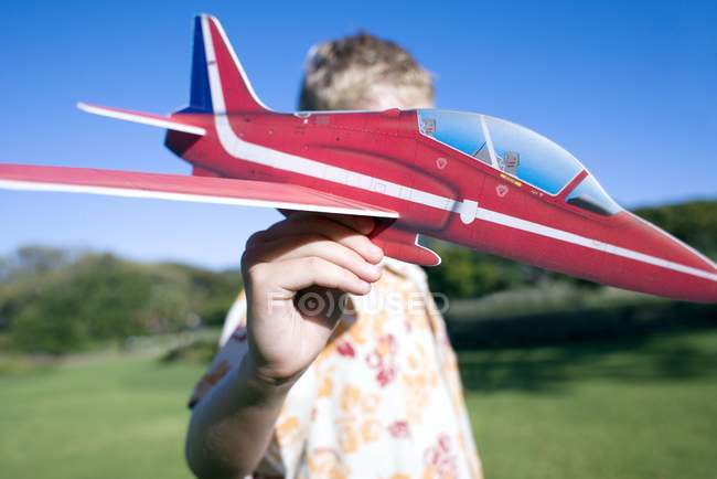 Мальчик играет с моделью самолета в парке . — стоковое фото