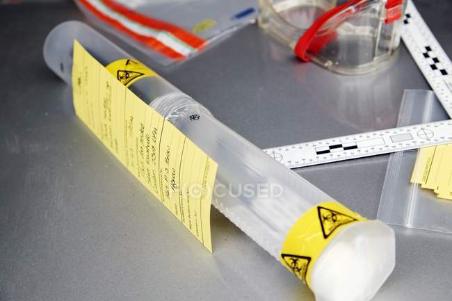 Recipiente com fita de advertência de risco biológico contendo provas forenses . — Fotografia de Stock