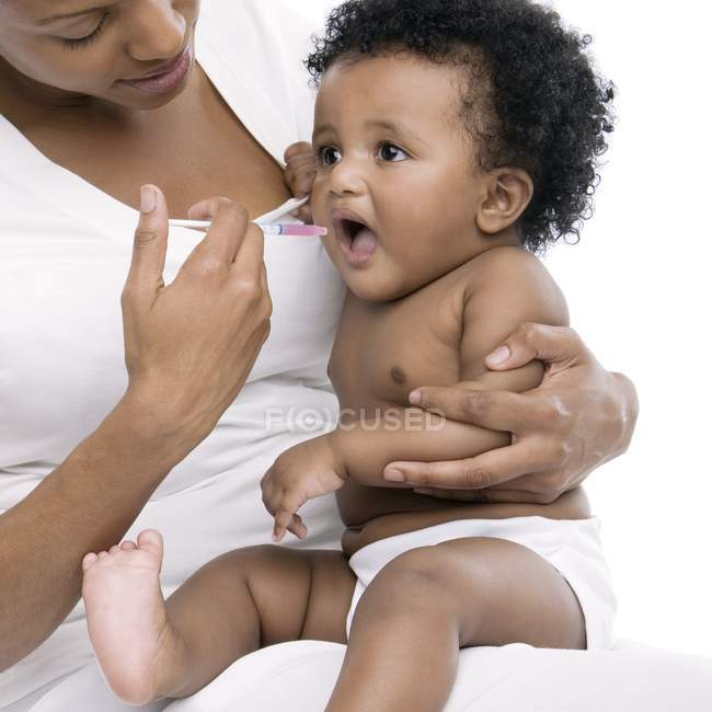 Mãe dando seringa com medicamento para o bebê . — Fotografia de Stock