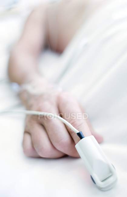 Primer plano del oxímetro de pulso en la mano del paciente . - foto de stock