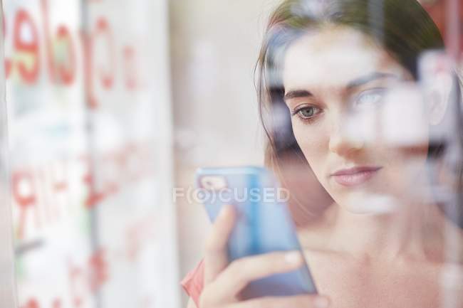 Woman holding smartphone and looking down. — Stock Photo