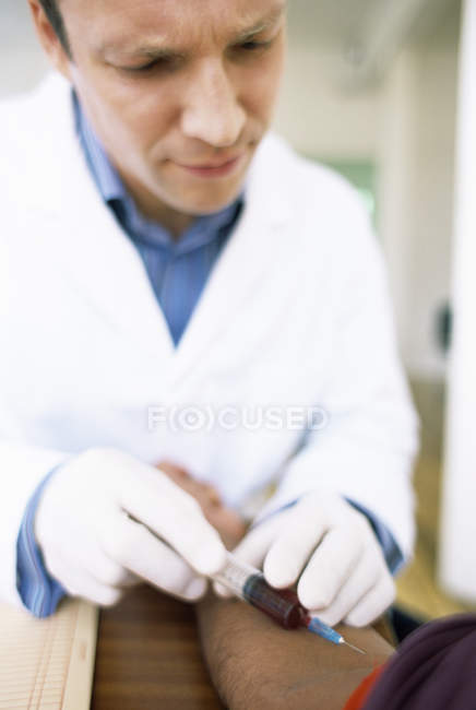 Doctor taking blood sample from patient arm. — Stock Photo
