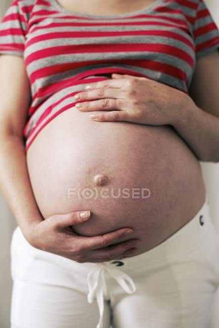 Vue recadrée de l'abdomen de la femme enceinte . — Photo de stock