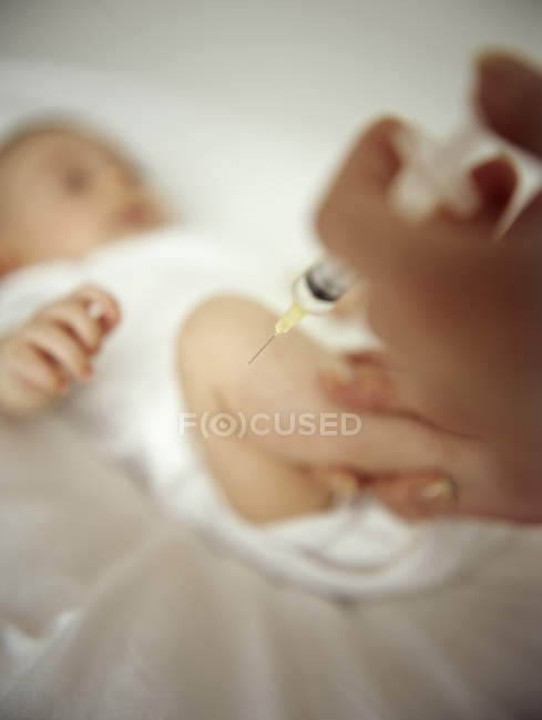 Baby girl having injection in leg. — Stock Photo