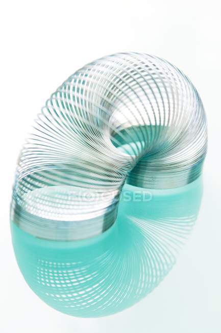 Slinky Spielzeug mit Reflexion auf weißem Hintergrund. — Stockfoto