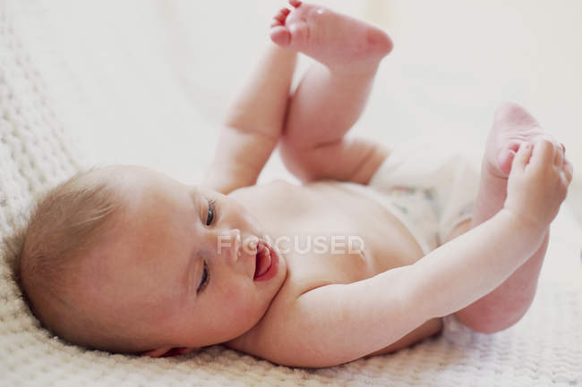 Newborn baby girl lying on back. — Stock Photo