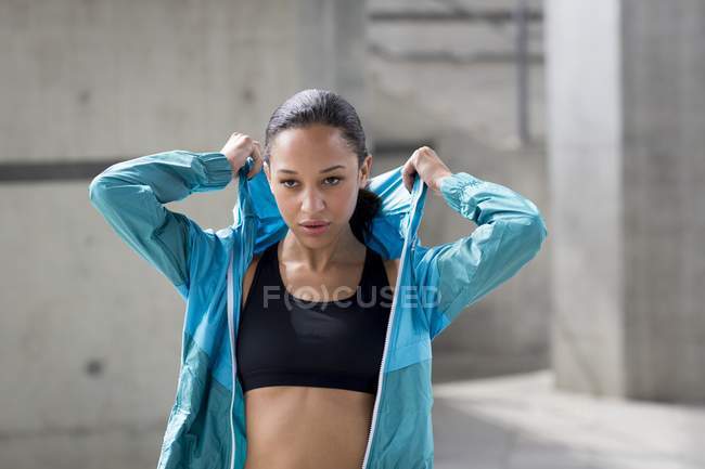 Woman putting on hooded top — Stock Photo