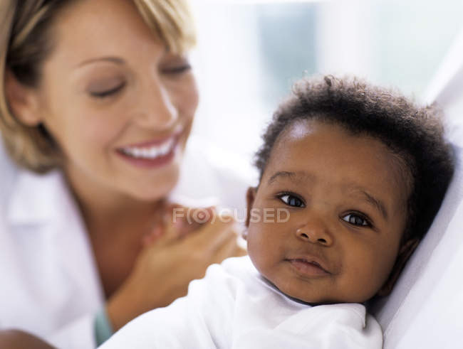 Médecin féminin examinant bébé garçon . — Photo de stock