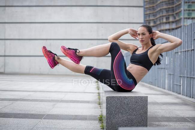 Woman exercising on wall — Stock Photo