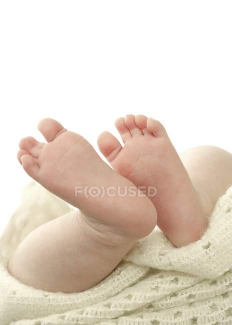 Close-up of infant baby feet on blanket. — Stock Photo