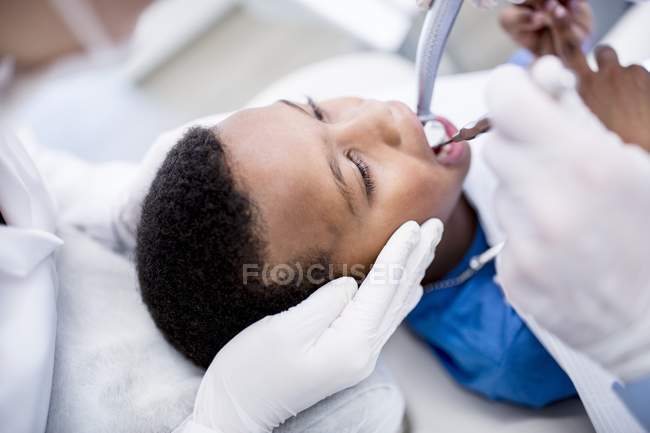 Close-up of dentist drilling boy teeth in clinic. — Stock Photo