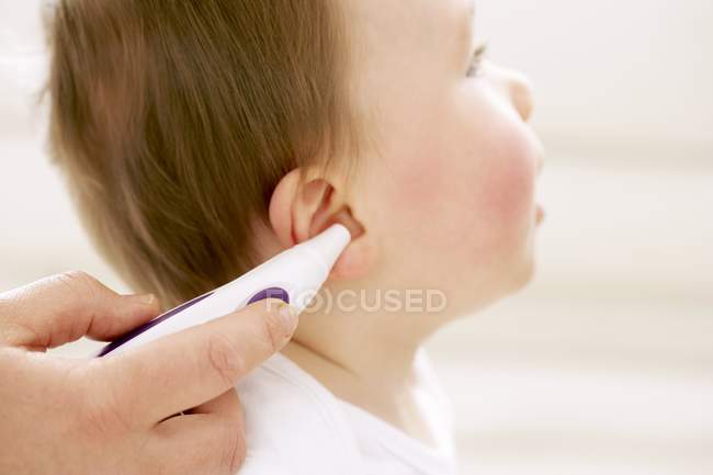 Mother using digital thermometer for measuring baby son temperature. — Stock Photo
