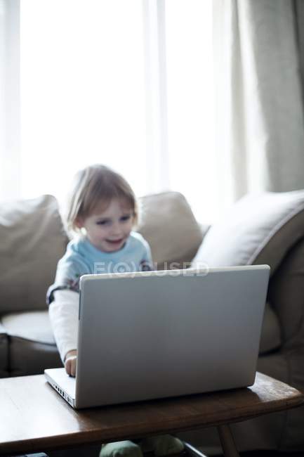 Criança brincando com computador portátil . — Fotografia de Stock