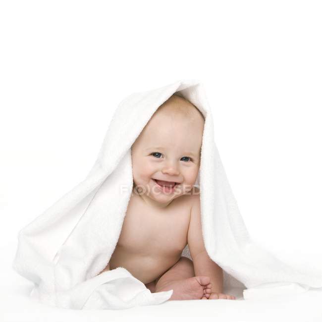 Niño sonriendo debajo de la manta . - foto de stock
