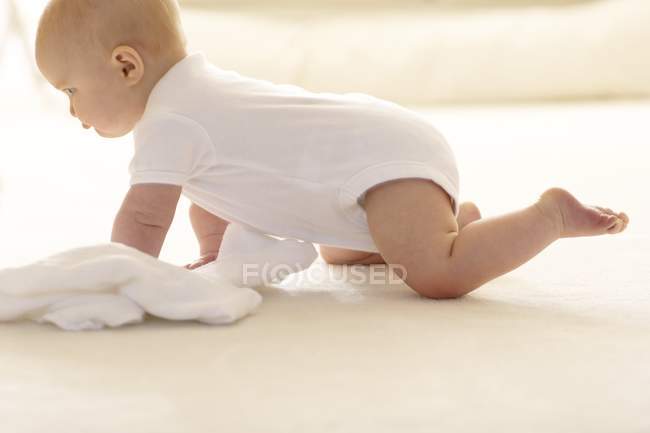 Baby girl crawling across the floor. — Stock Photo