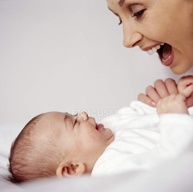 Madre e bambina sorridendo mentre si guardano . — Foto stock