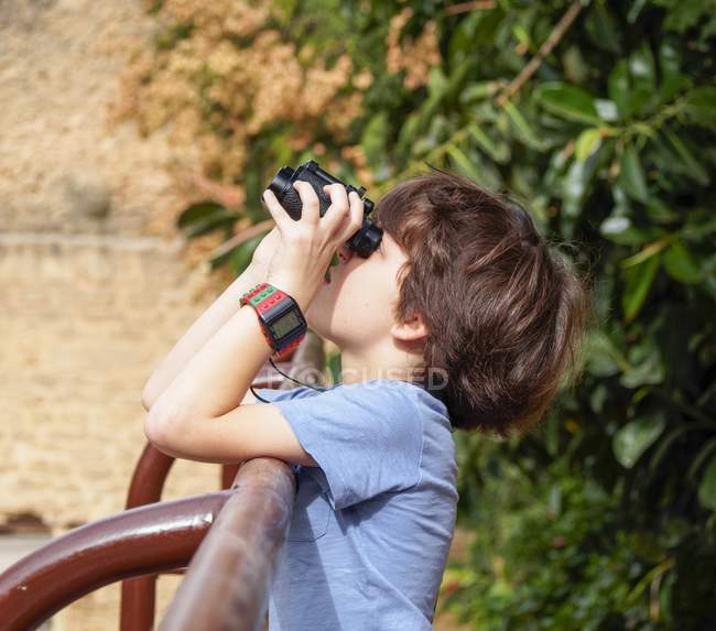 Young male birdwatcher looking through binoculars — Stock Photo