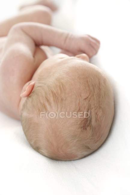 Newborn baby boy lying on white background. — Stock Photo