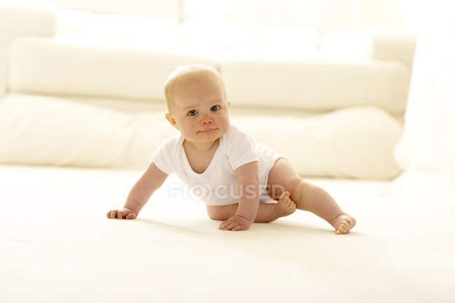Bambina strisciare attraverso il pavimento . — Foto stock
