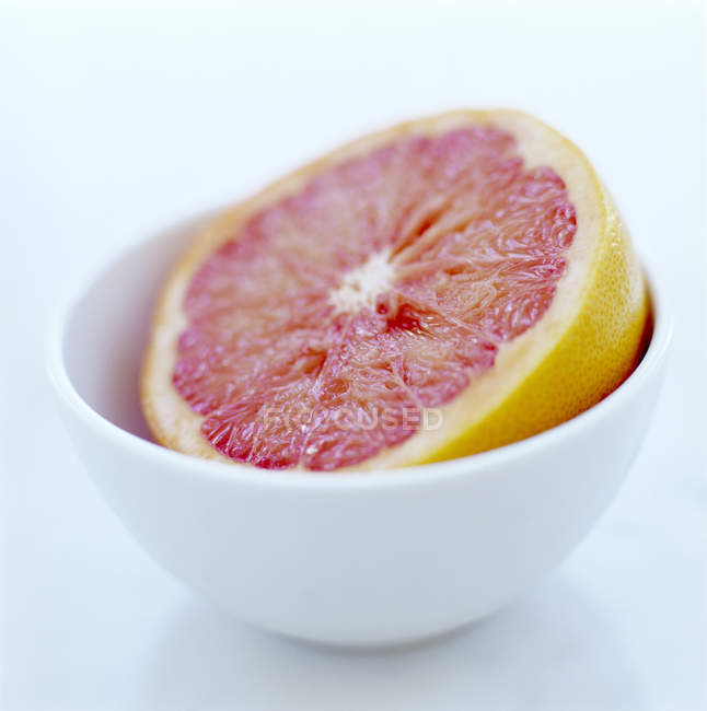 Close-up view of pink grapefruit half in bowl. — Stock Photo