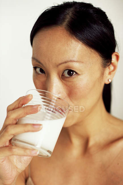Asiatische Frau trinken Glas Milch. — Stockfoto