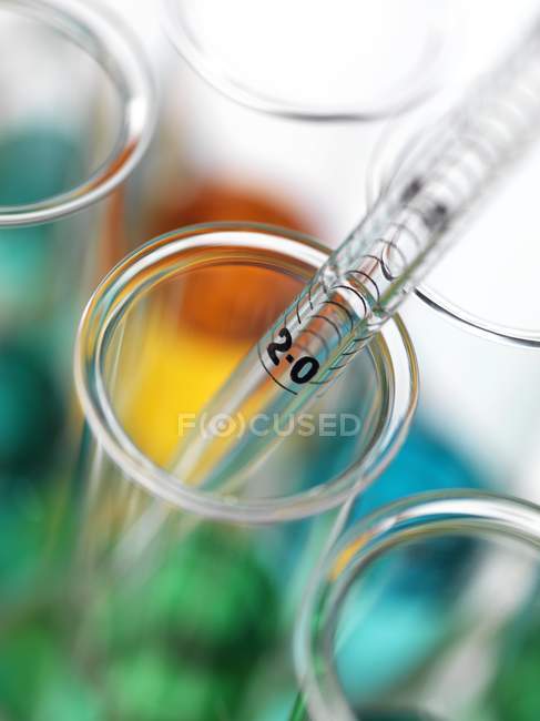 Close-up de pipetagem de líquidos coloridos em tubos de ensaio . — Fotografia de Stock