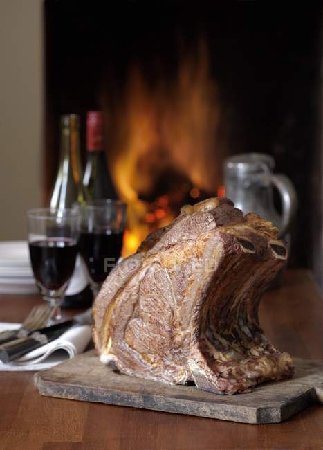Cooked rack of beef with wine on table. — Stock Photo