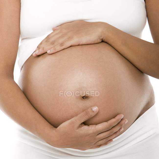 Обрізаний вид вагітної жінки, що тримає живіт . — стокове фото