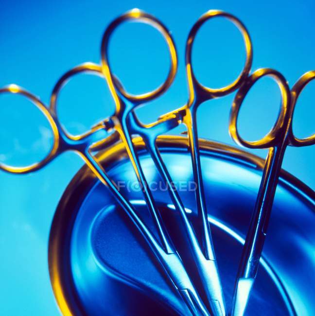 Vista ravvicinata delle pinze chirurgiche in una ciotola di metallo . — Foto stock