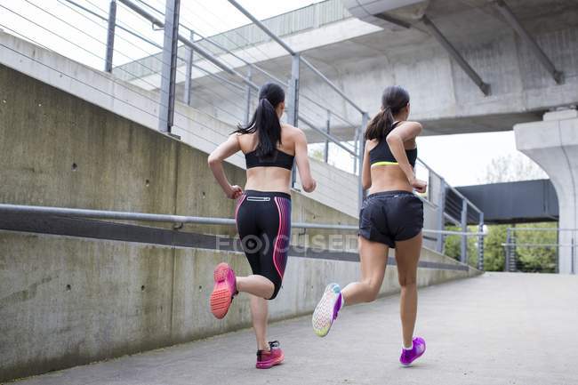 Mujeres que corren en el entorno urbano - foto de stock