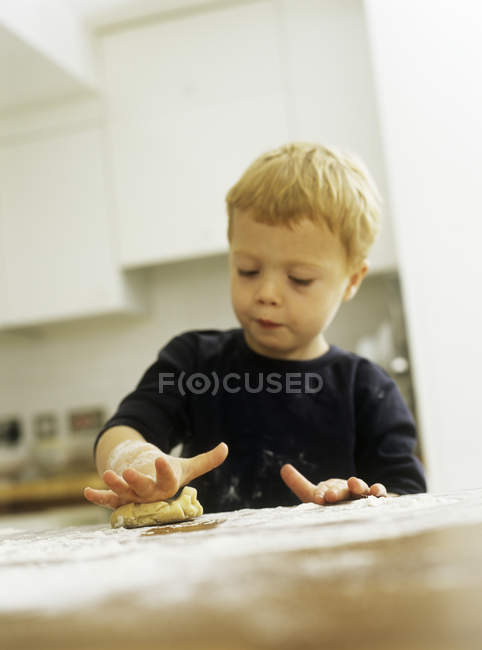 Мальчик-дошкольник катит печенье . — стоковое фото