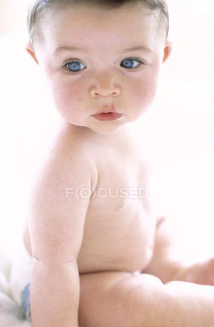 Baby boy sitting and looking away. — Stock Photo