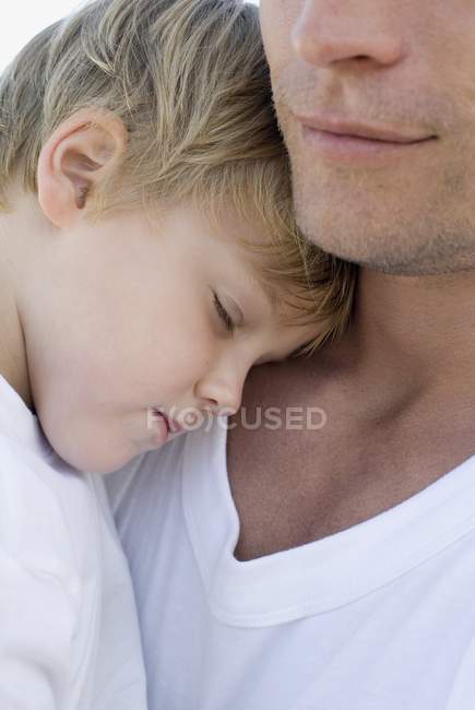Батько приборкання спить на грудях сина . — стокове фото