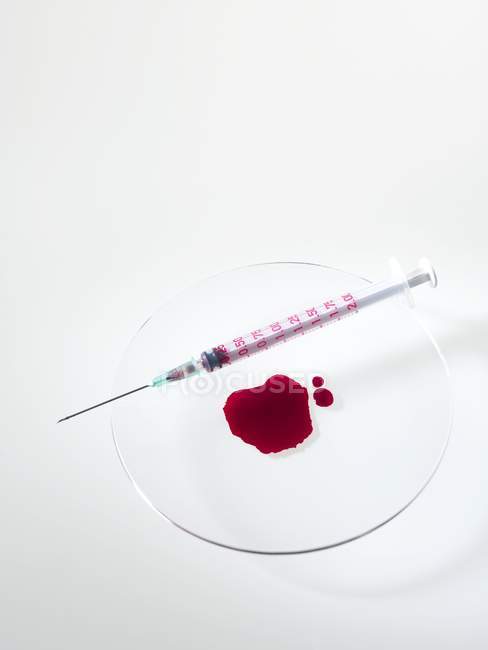 Piscina de sangue em vidro de relógio com seringa . — Fotografia de Stock