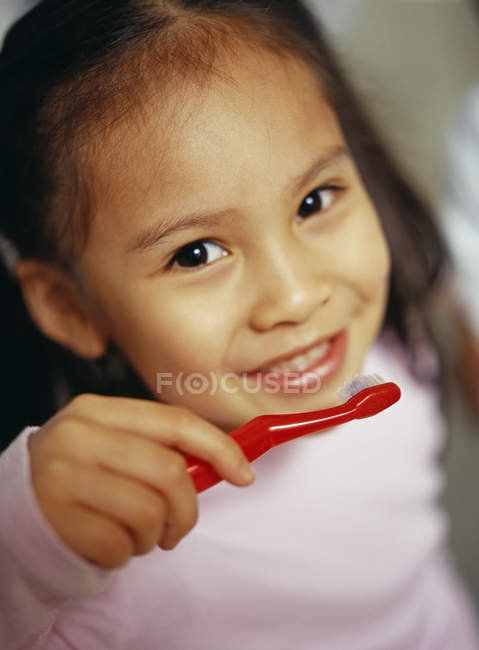 Jeune fille brossant les dents pour prévenir la carie dentaire — Photo de stock