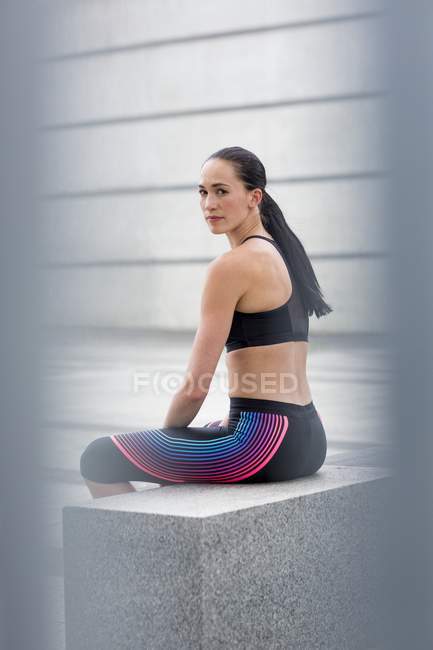 Frau sitzt auf Mauer — Stockfoto