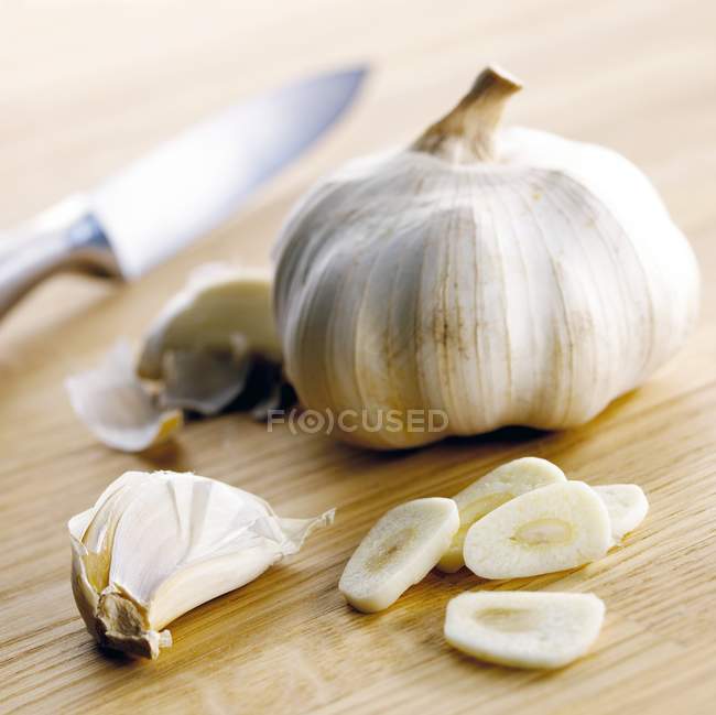 Lampadina di aglio e chiodi di garofano su tavola di legno . — Foto stock