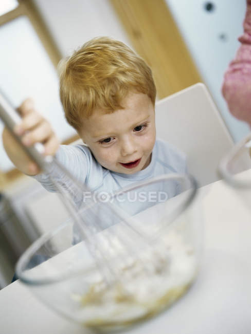 Preschooler boy mixing ingredients in bowl. — Stock Photo