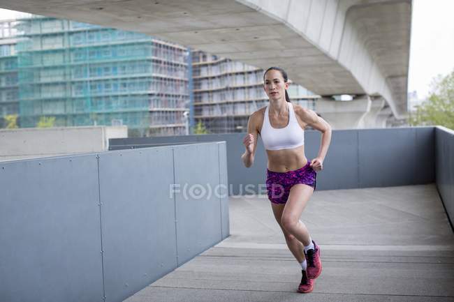 Jovem mulher correndo em cena urbana . — Fotografia de Stock