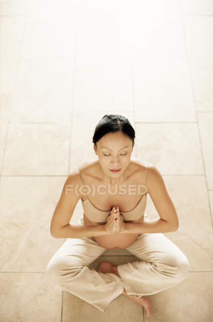 Pregnant woman in seated yoga pose. — Stock Photo
