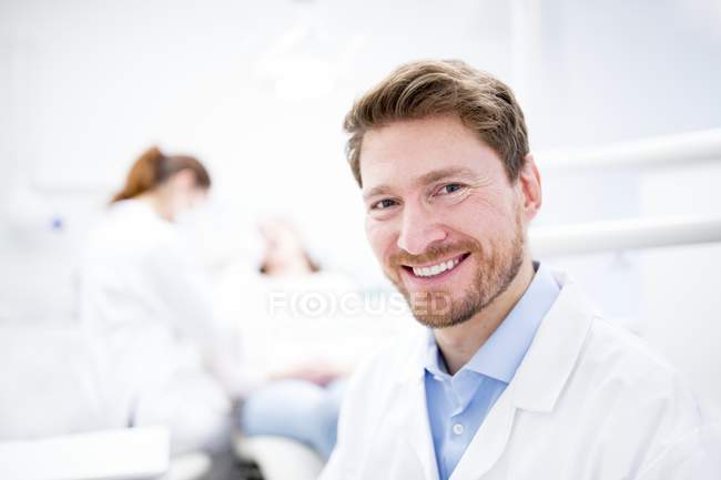 Retrato del dentista masculino adulto medio en la clínica . - foto de stock