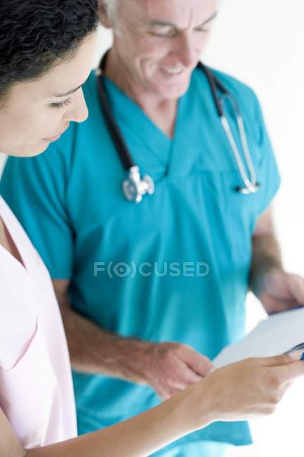 Medico e infermiere discutere cartelle cliniche . — Foto stock