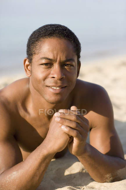 Portrait on man lying on front on beach. — Stock Photo
