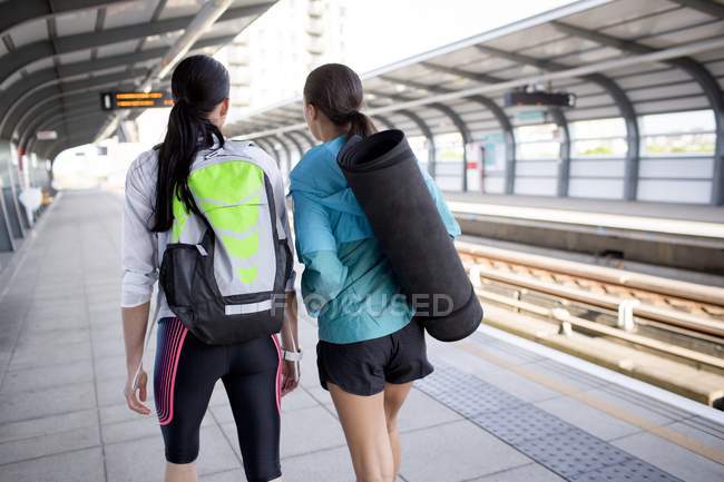 Women with sports equipment on railway platform — Stock Photo
